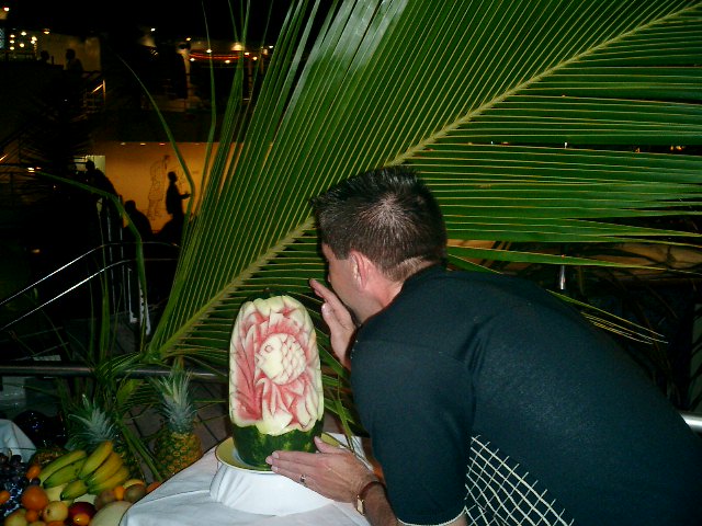 Rex dares to touch the magnificent piece of watermelon art. Click to display the image.